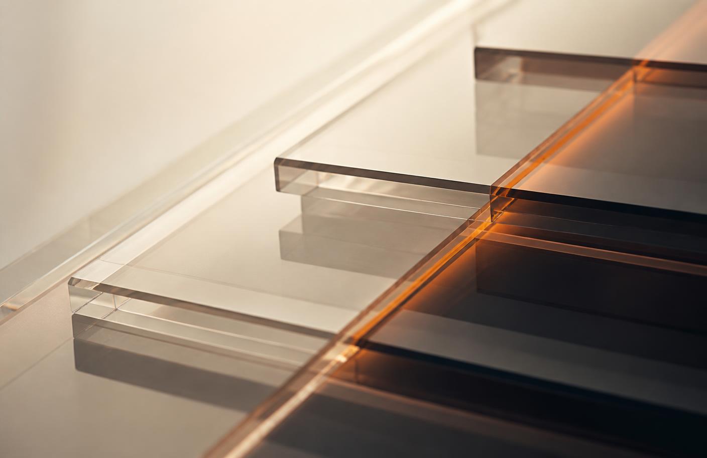 Abstract macro photograph of stacked translucent glass panels with a warm orange edge highlight